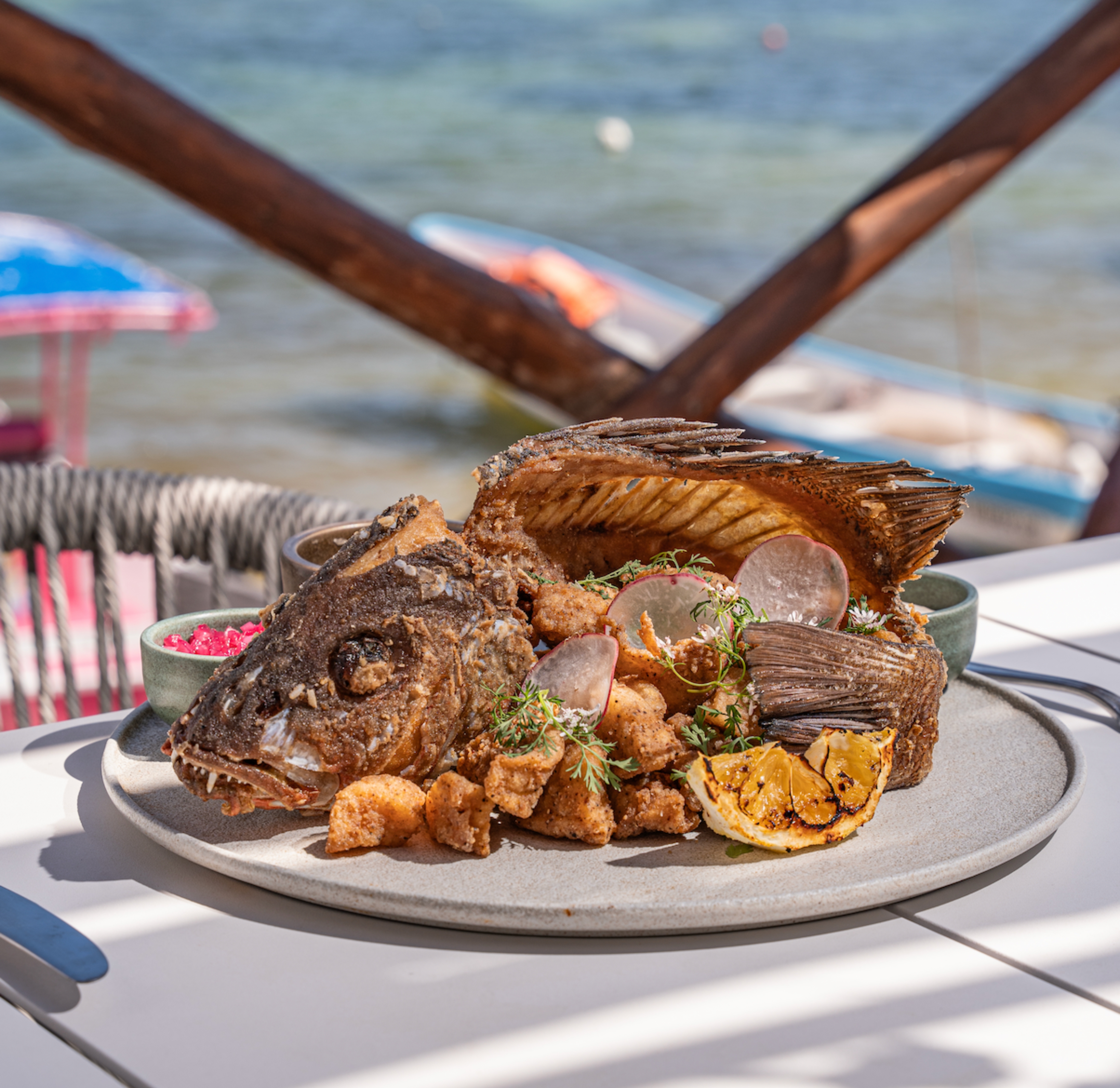 Pescado entero frito frente al mar